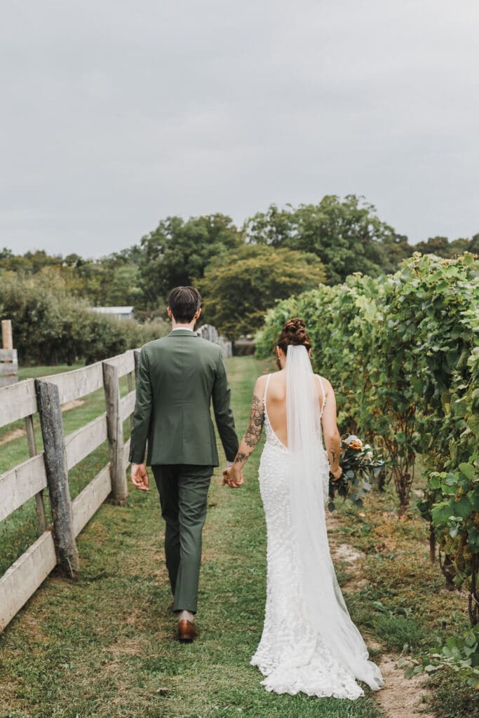 Bride and groom walking through the vineyard at Waupoos Estates Winery in Prince Edward County