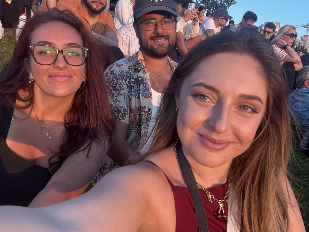Friends enjoying an outdoor sunset in Porto, Portugal, on a warm summer evening.