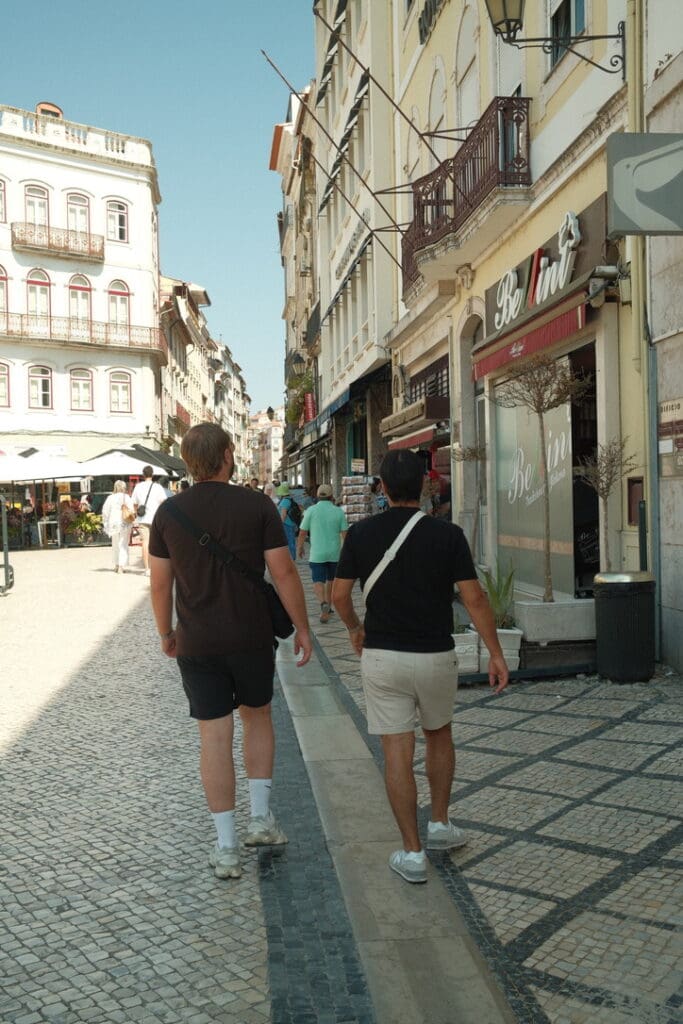 Exploring the historic streets of Coimbra, Portugal, with its charming architecture, local shops, and traditional Portuguese mosaic sidewalks