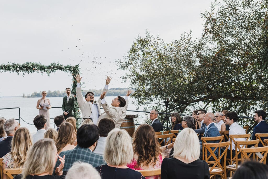 Groomsmen celebrating during the wedding ceremony at Waupoos Estates Winery