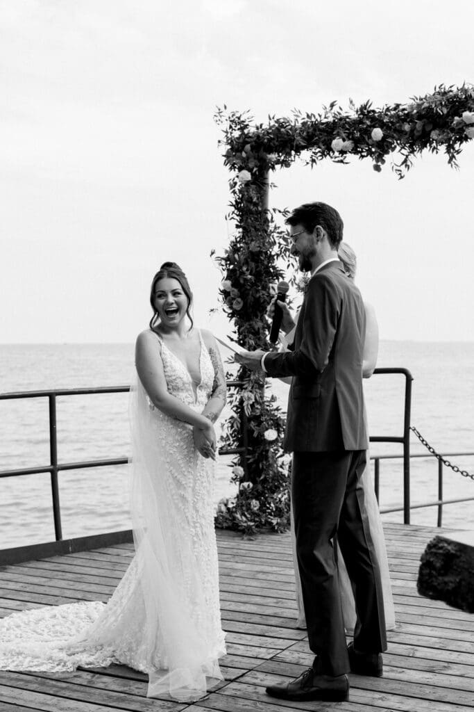 Midori and Joe exchanging vows during their waterfront ceremony at Waupoos Estates Winery
