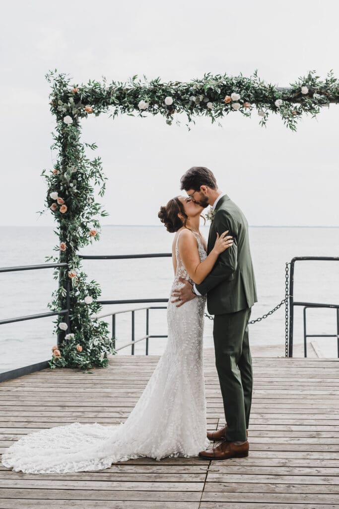 Midori and Joe sharing a kiss during their wedding ceremony at Waupoos Estates Winery