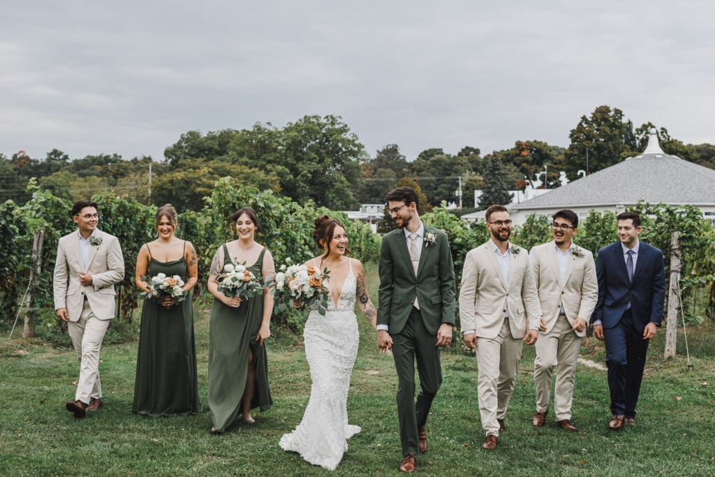 Bride, groom, bridesmaids, and groomsmen walking together outdoors following the wedding ceremony at Waupoos Estates Winery.