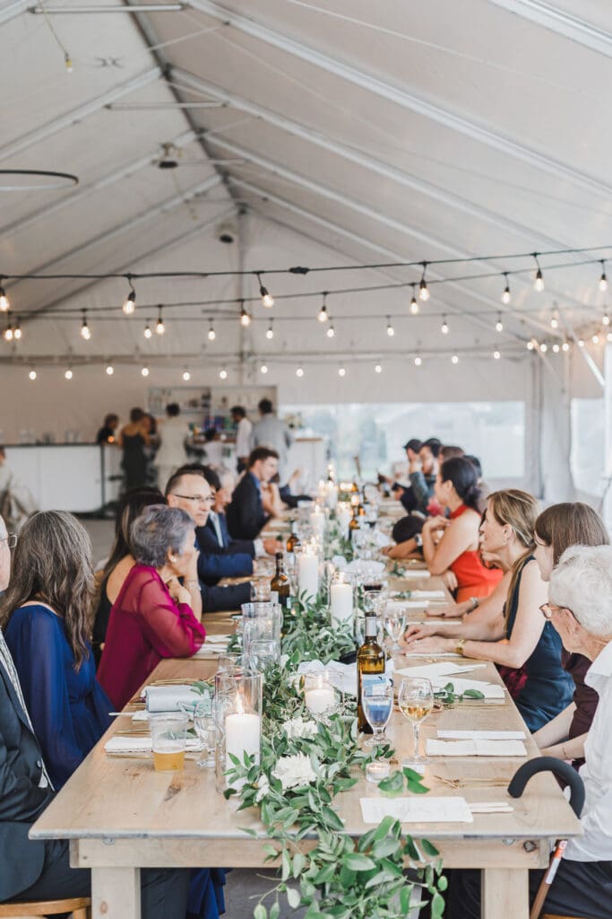 Wedding guests enjoying dinner and conversation during the reception at Waupoos Estates Winery.